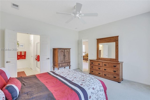 carpeted bedroom with a textured ceiling, ceiling fan, and ensuite bathroom