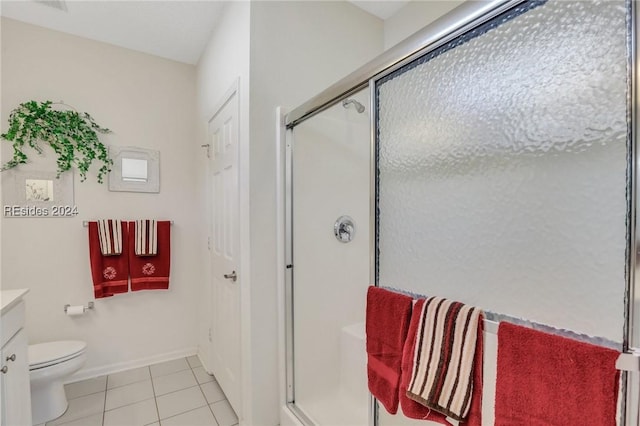 bathroom featuring tile patterned floors, vanity, toilet, and a shower with shower door