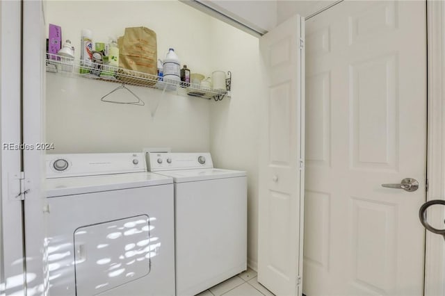 clothes washing area with light tile patterned floors and washing machine and clothes dryer