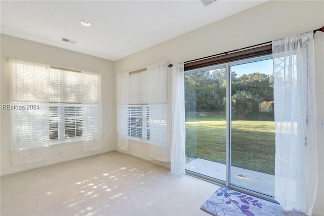 doorway to outside featuring light carpet