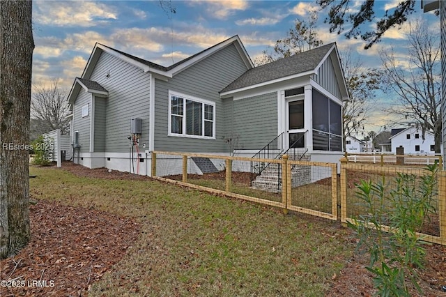 view of front of house with a sunroom and a lawn