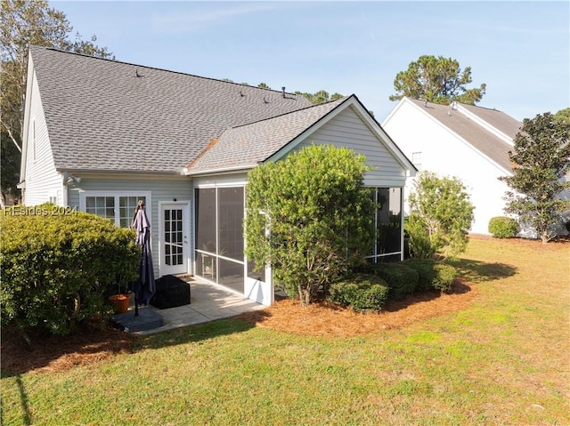 rear view of property featuring a sunroom and a lawn