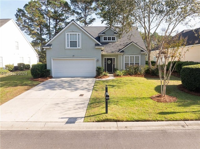 view of property featuring a garage and a front lawn