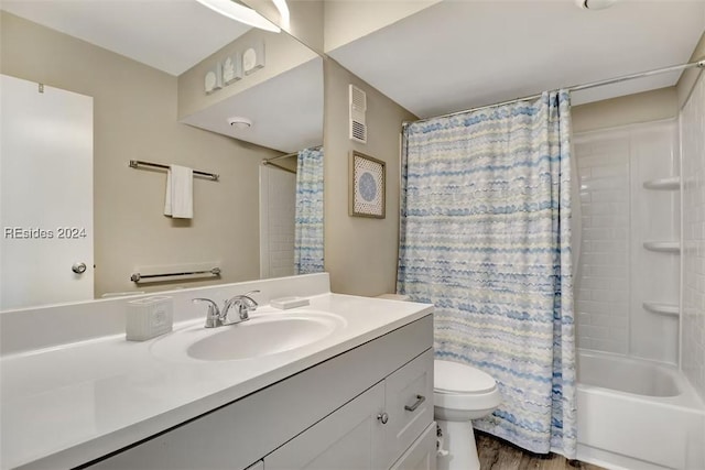 full bathroom with hardwood / wood-style flooring, vanity, shower / tub combo, and toilet