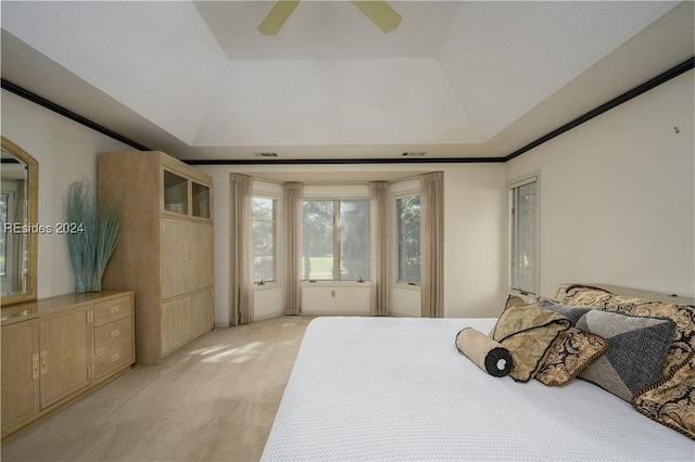 bedroom featuring ceiling fan, ornamental molding, a raised ceiling, and light colored carpet