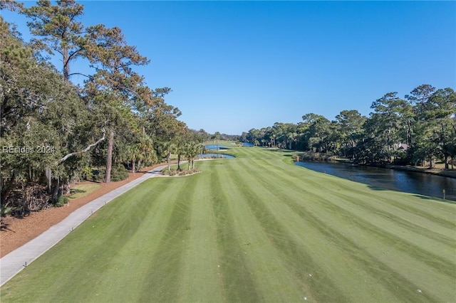 view of property's community with a water view and a lawn