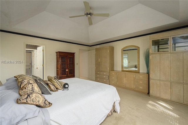 bedroom featuring light carpet, ceiling fan, and a tray ceiling