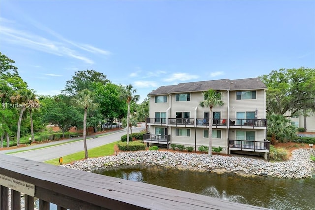 rear view of property with a balcony and a water view