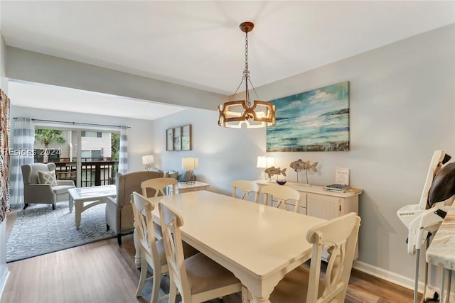 dining space featuring hardwood / wood-style flooring and a chandelier