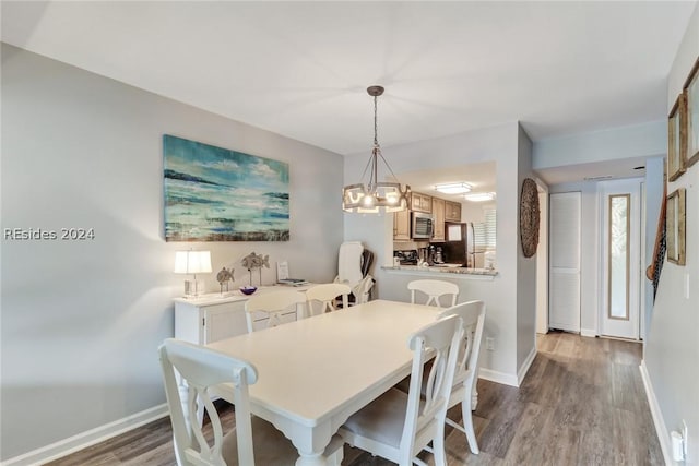 dining area with hardwood / wood-style flooring and a notable chandelier