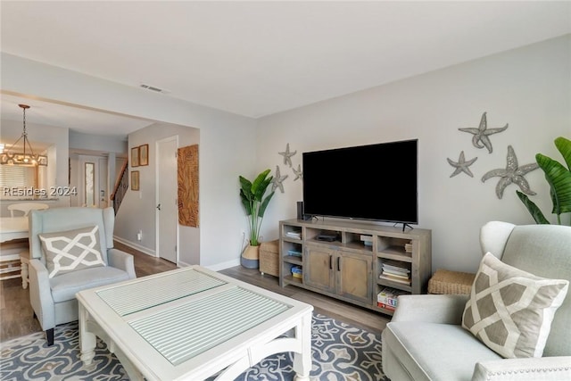 living room with dark hardwood / wood-style flooring and a chandelier