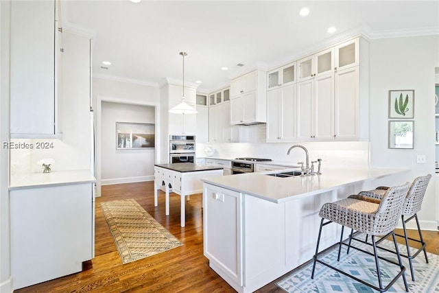 kitchen with pendant lighting, sink, white cabinetry, dark hardwood / wood-style flooring, and kitchen peninsula