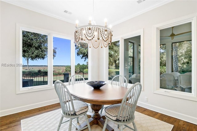 dining space featuring crown molding, a notable chandelier, and dark hardwood / wood-style flooring