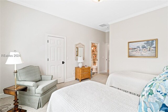 bedroom featuring crown molding, light colored carpet, and ensuite bath