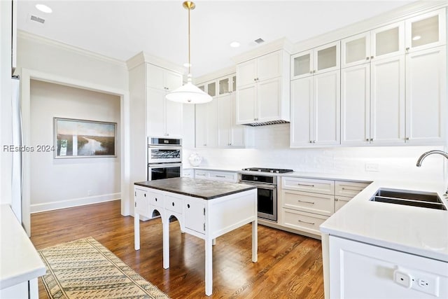 kitchen featuring appliances with stainless steel finishes, decorative light fixtures, sink, and white cabinets