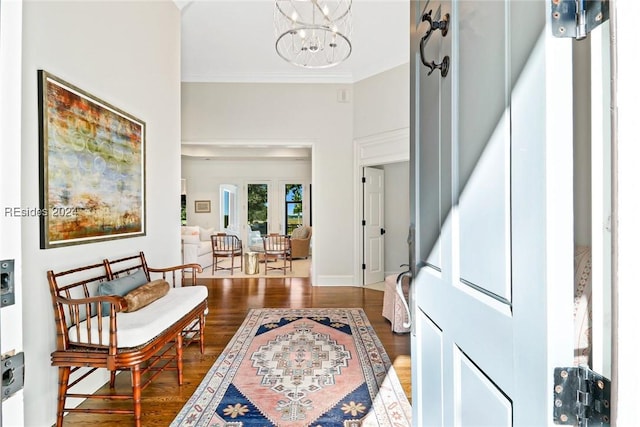 entryway with ornamental molding, dark hardwood / wood-style floors, and a chandelier