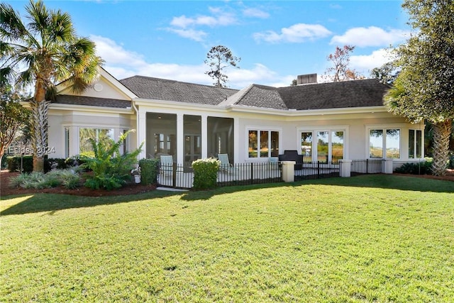 back of property featuring a yard and a sunroom