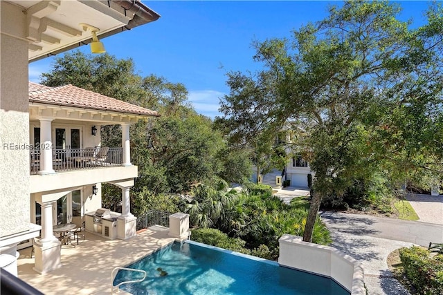 view of pool featuring a patio and an outdoor kitchen