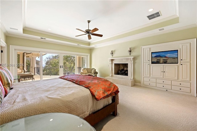 bedroom with ceiling fan, a raised ceiling, light colored carpet, and access to outside