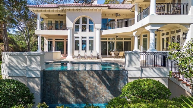 rear view of house with a patio area, a balcony, and ceiling fan