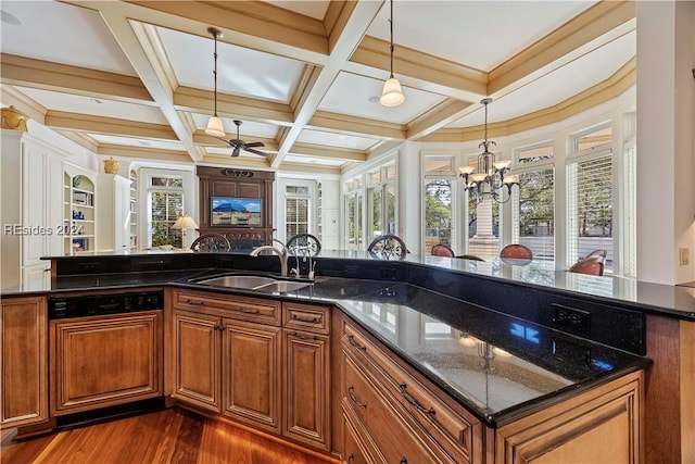 kitchen featuring decorative light fixtures, beamed ceiling, sink, dark stone countertops, and coffered ceiling