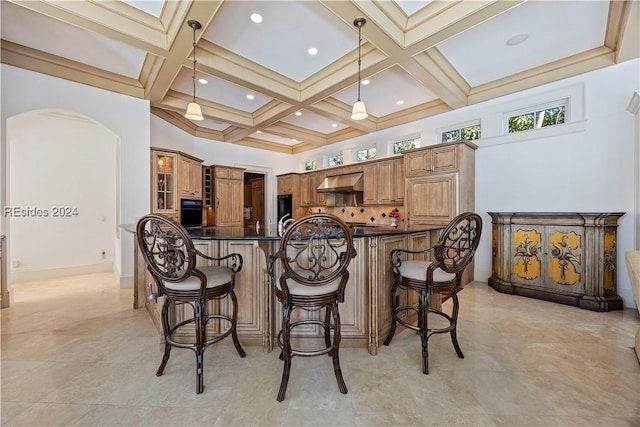 kitchen with decorative light fixtures, beamed ceiling, coffered ceiling, kitchen peninsula, and wall chimney exhaust hood