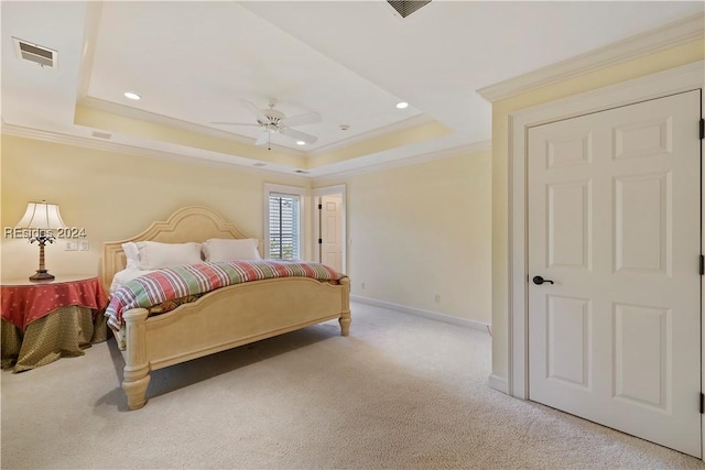 bedroom featuring ornamental molding, light colored carpet, ceiling fan, and a tray ceiling