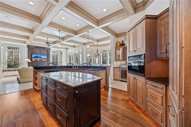 kitchen with wine cooler, plenty of natural light, a center island, and oven