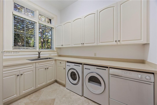 laundry area with separate washer and dryer, sink, and cabinets