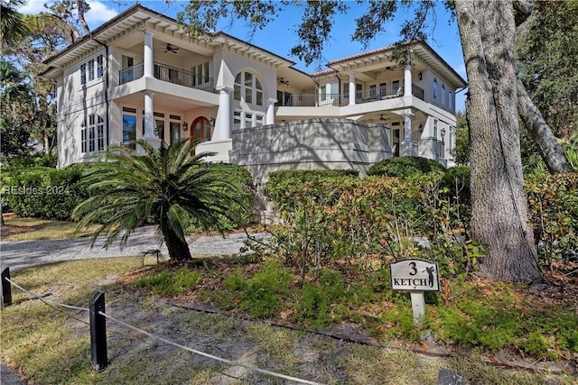 view of front facade featuring ceiling fan and a balcony