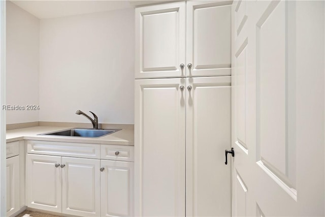 kitchen featuring white cabinetry and sink