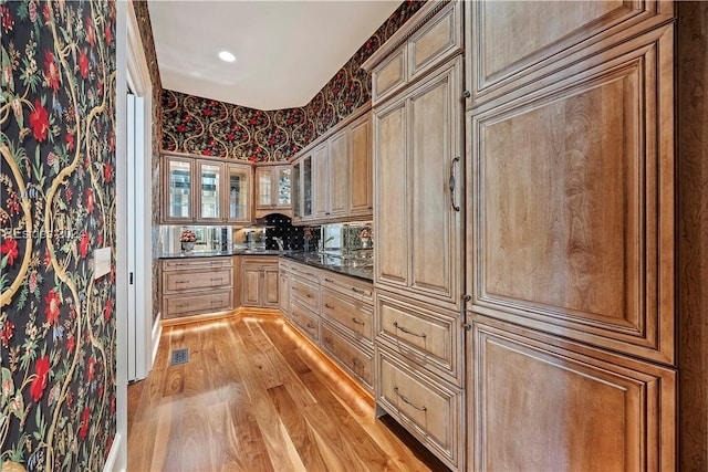 kitchen with dark stone counters and light wood-type flooring