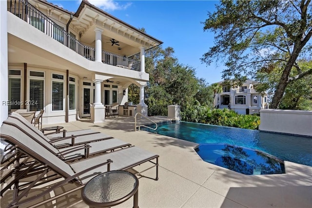 view of swimming pool featuring pool water feature, ceiling fan, and a patio area