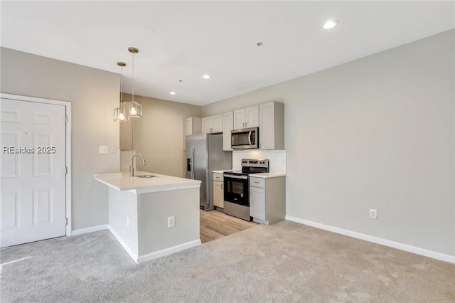 kitchen featuring appliances with stainless steel finishes, decorative light fixtures, light carpet, and kitchen peninsula