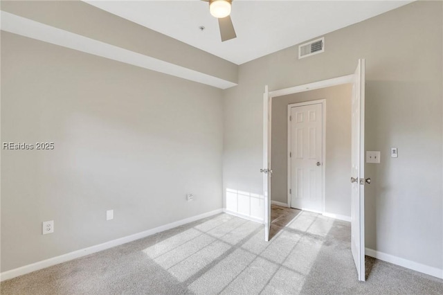 carpeted spare room featuring ceiling fan