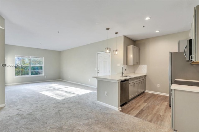 kitchen featuring sink, gray cabinetry, hanging light fixtures, backsplash, and stainless steel appliances