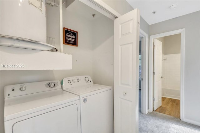 clothes washing area with light colored carpet and independent washer and dryer