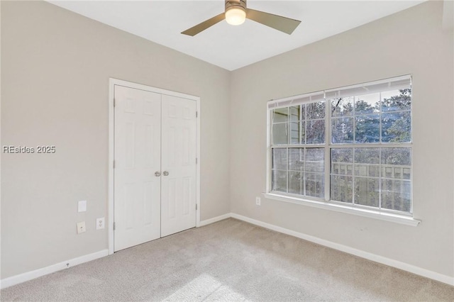 unfurnished bedroom featuring a closet, ceiling fan, and carpet