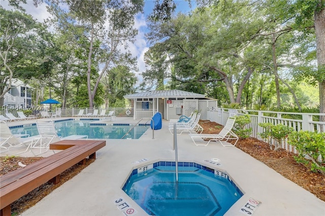 view of pool featuring a hot tub and a patio