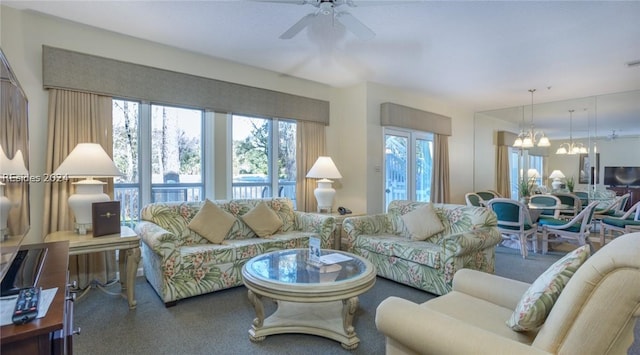 carpeted living room featuring ceiling fan with notable chandelier