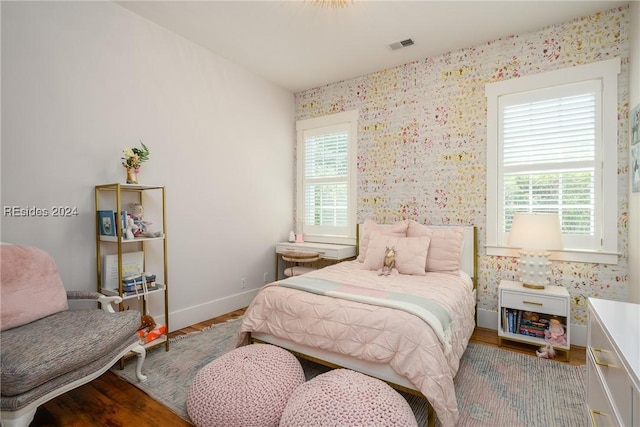 bedroom with hardwood / wood-style flooring and multiple windows