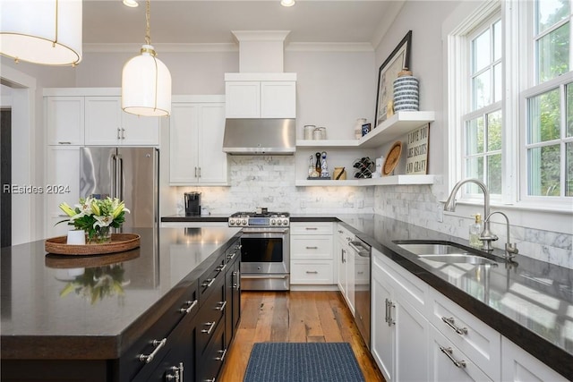 kitchen with sink, white cabinetry, tasteful backsplash, decorative light fixtures, and stainless steel appliances