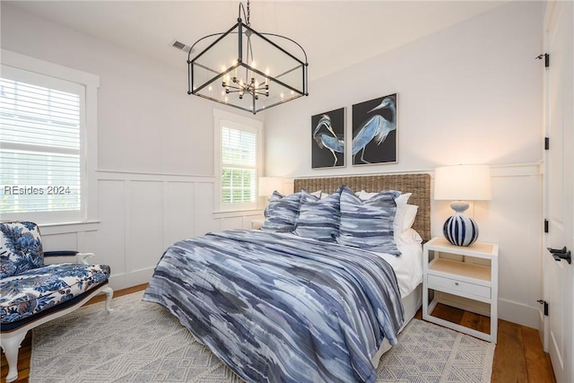 bedroom with an inviting chandelier and wood-type flooring