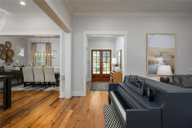 miscellaneous room with hardwood / wood-style flooring, ornamental molding, a chandelier, and french doors