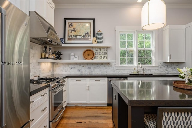 kitchen featuring sink, white cabinets, pendant lighting, stainless steel appliances, and backsplash