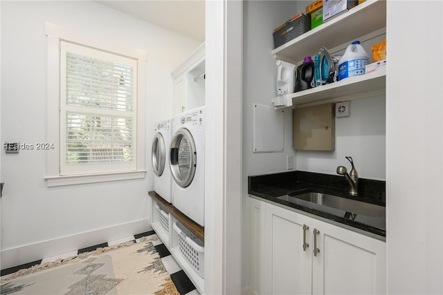 clothes washing area featuring cabinets, separate washer and dryer, and sink