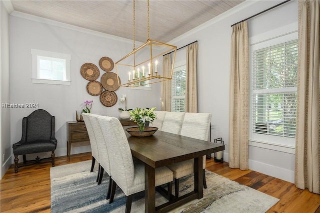 dining area with crown molding, a notable chandelier, a wealth of natural light, and hardwood / wood-style flooring