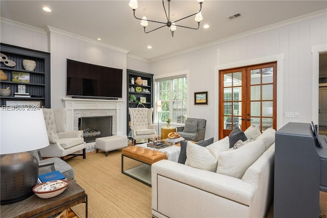 living room with crown molding, built in features, and french doors