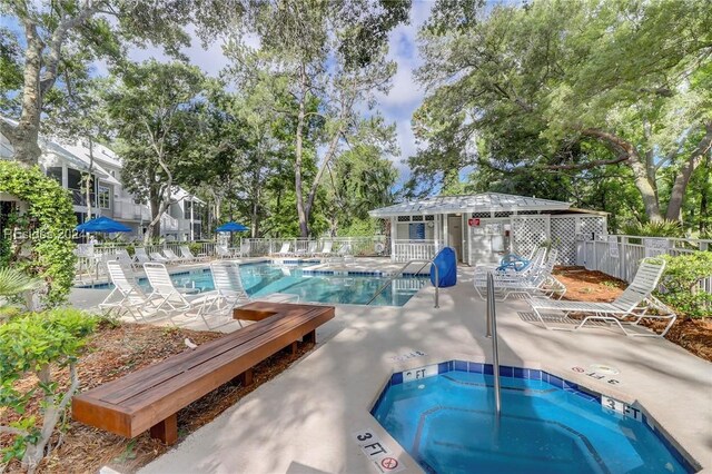 view of pool with a hot tub and a patio