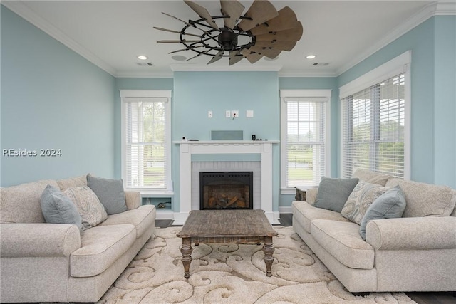 living room featuring crown molding, ceiling fan, and a fireplace